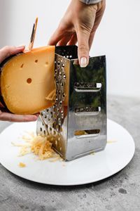 Close-up of person grating cheese