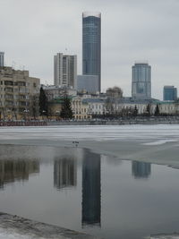 Reflection of buildings in lake against sky