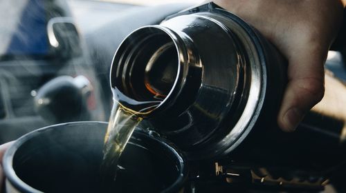 Close-up of hand holding thermos