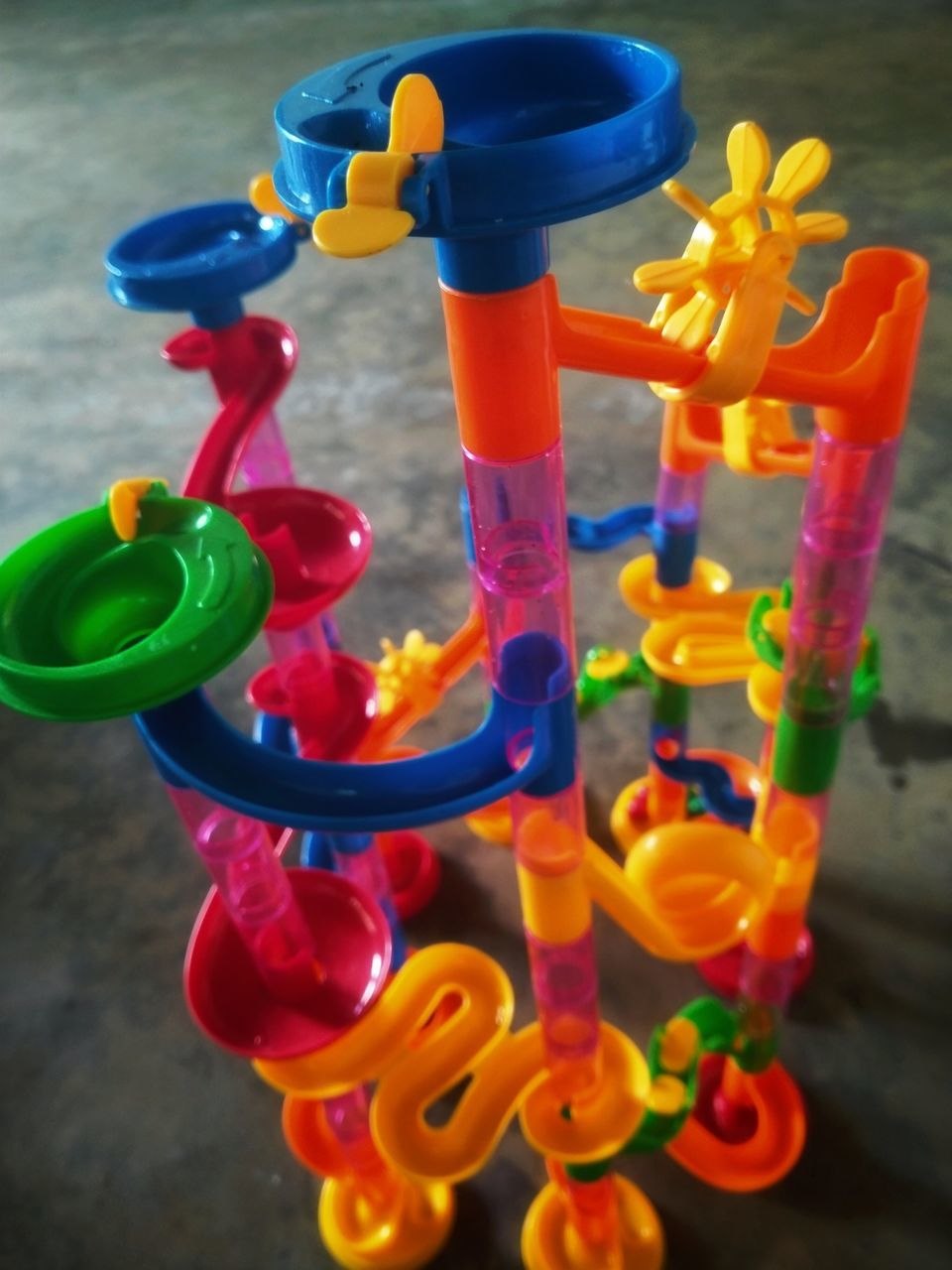 HIGH ANGLE VIEW OF MULTI COLORED TOY ON TABLE