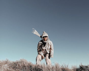 Low angle view of man on field against clear sky