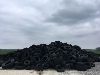 Stack of stones on field against sky