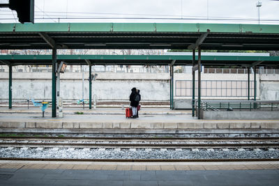 Rear view of man walking on railroad station