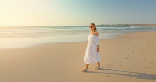 Rear view of woman standing at beach