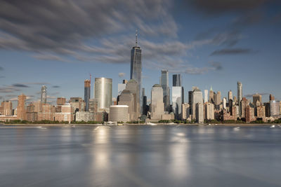 Modern buildings in city against cloudy sky