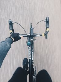 Low section of person riding bicycle on road