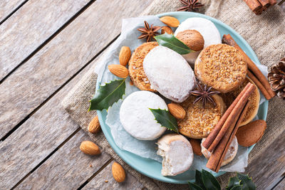 Traditional spanish christmas sweets, shortbread mantecados and polvorones on a wooden table