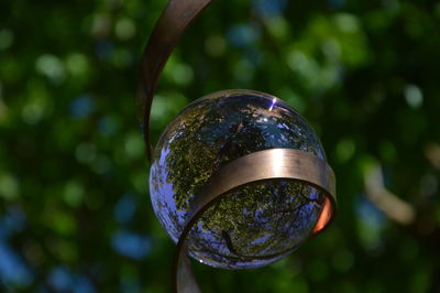 Close-up of water drop hanging on metal