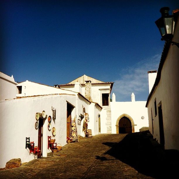 architecture, built structure, building exterior, clear sky, religion, place of worship, spirituality, blue, sunlight, church, history, facade, entrance, copy space, day, statue, sky, low angle view