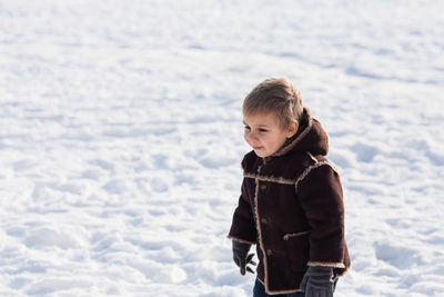 Boy with jacket on snow during winter