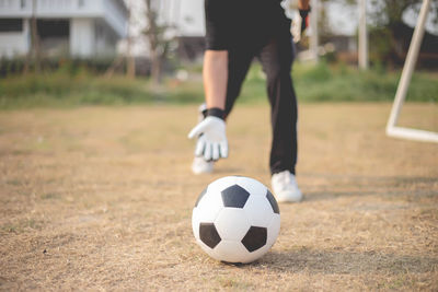 Low section of woman playing soccer ball on field