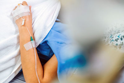 Close-up of woman hand with medical equipment on bed