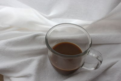 Close-up of tea cup on bed