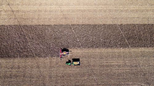 Drone view of tractors plowing agricultural field