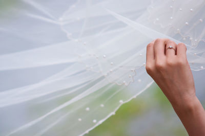 Close-up of hand holding white dress