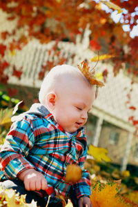 Cute baby girl with flowers on tree