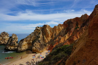 Scenic view of sea by mountains against sky