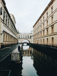 Reflection of bridge on canal in city