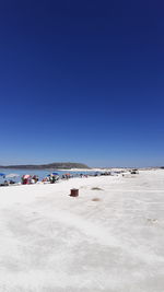 Scenic view of beach against clear blue sky