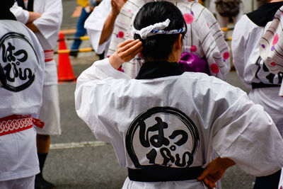 Rear view of people standing against the wall