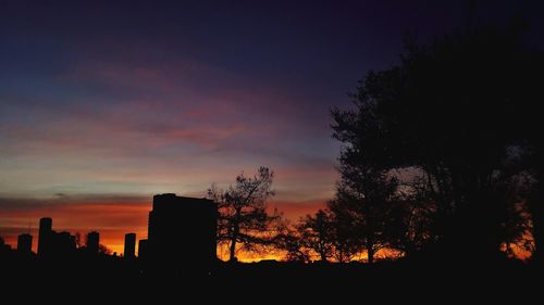 Silhouette trees against sky at sunset