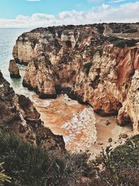 Rocks on sea shore against sky