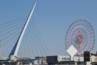 Low angle view of ferris wheel against blue sky