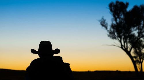 Silhouette woman against clear sky during sunset