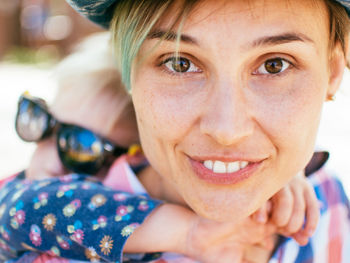 Portrait of smiling mother giving piggyback ride to daughter