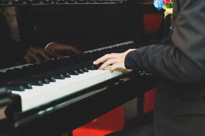 Midsection of man playing piano