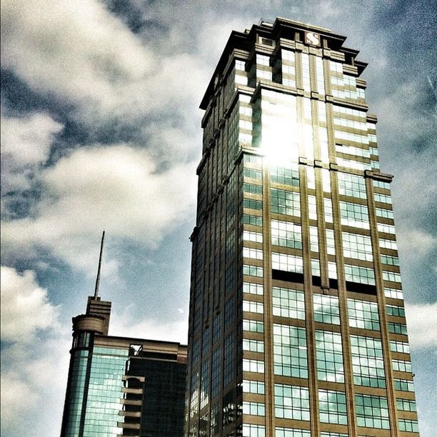 architecture, low angle view, building exterior, built structure, sky, tower, tall - high, cloud - sky, city, modern, cloudy, skyscraper, office building, building, cloud, tall, glass - material, day, window, outdoors