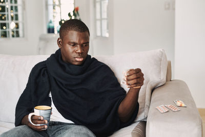 Mid adult man sitting on sofa at home