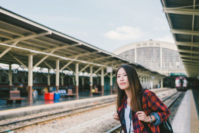 Woman standing on railroad station platform