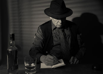 Man drinking alcohol while sitting at table