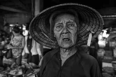 Close-up portrait of senior woman wearing asian style conical hat