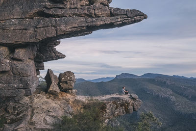 Rock formations by mountain against sky