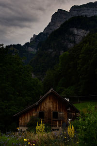 House by trees and mountains against sky