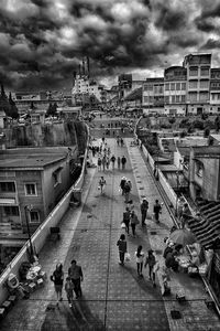 High angle view of people in city against cloudy sky