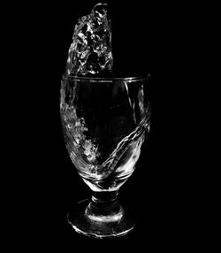 Close-up of wineglass against black background