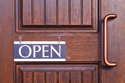 Close-up of information sign on wooden door