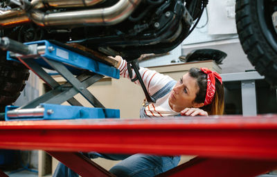 Mechanic woman checking motorcycle over platform