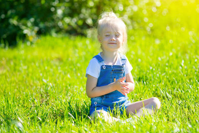 Girls running around the lawn with grass playing with splashes of water to water the plants.