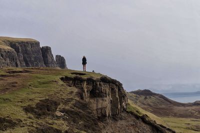 Rear view of woman standing on cliff