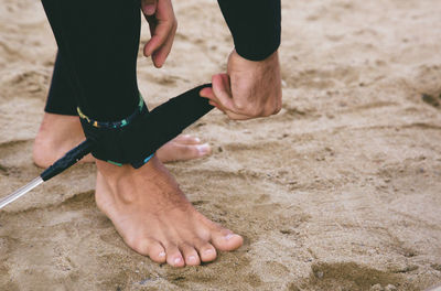 Low section of a surfer on beach