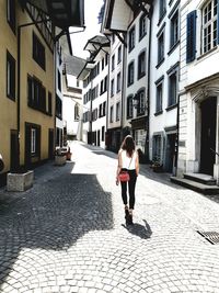 Full length of woman on street amidst buildings