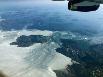 Aerial view of sea and airplane wing