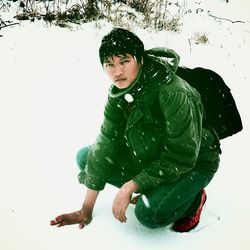 Young man with snow on field during winter