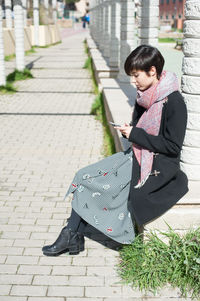 Woman standing on sidewalk in city