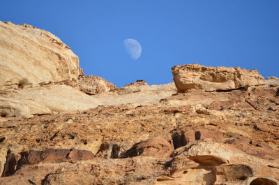 Low angle view of rock formation against clear blue sky