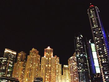 Illuminated cityscape against sky at night